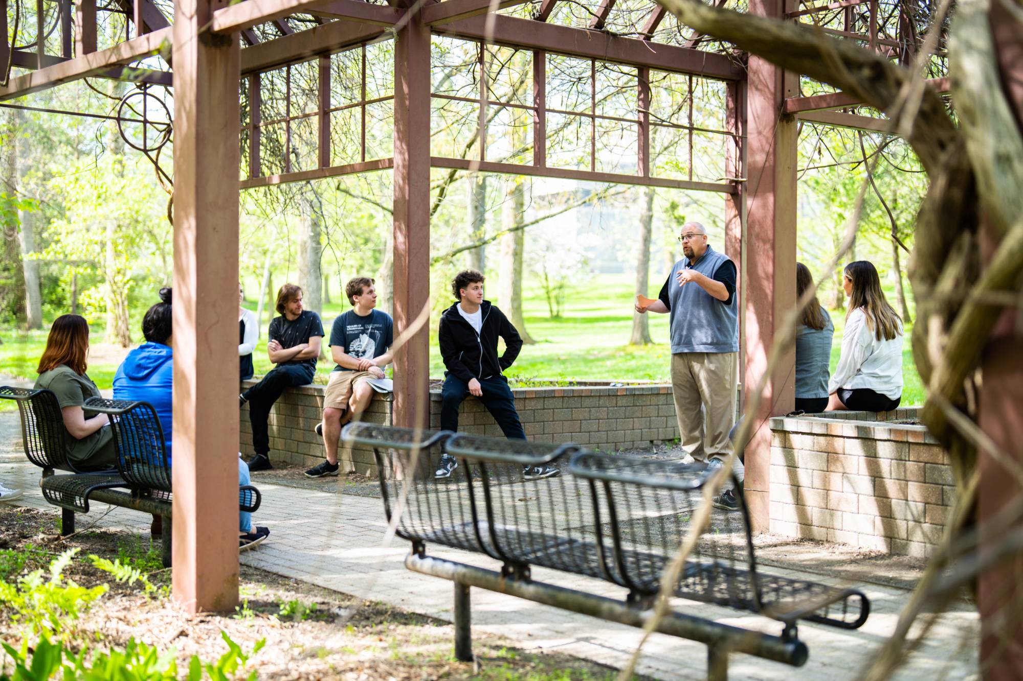 Professor Carl Brown teaches COM 201 to his students in the GVSU Arboritum